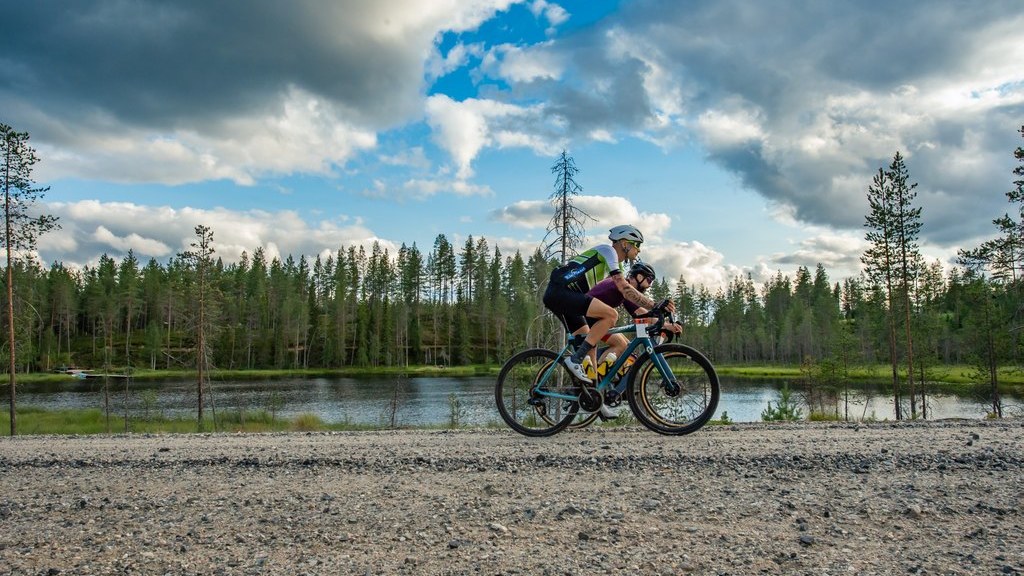 Gravel cyclists riding through the forest and lake landscapes of Ruka-Kuusamo